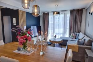 a living room with a table with flowers and candles at Luxury Heaven Apartment - 116 m2 Fireplace 3 bedroom - Free Parking in Katowice