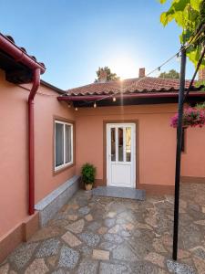 a pink house with a white door at Casa Family in Eforie Sud