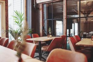 a restaurant with tables and chairs and a window at Havn Hotell og Restaurant in Skudeneshavn