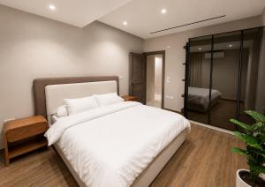 a bedroom with a large white bed and a walk in shower at Spacious 3BR Apartment in Prime Sheikh Zayed in Sheikh Zayed