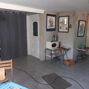 a living room with a table and a microwave at Vive le vert pomme ! in Saint-Romain-sur-Vienne