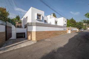 a white building with a gate on the side of a street at VILLA TAZA DE PLATA A in Huétor Vega