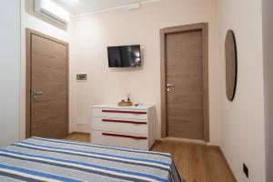 a bedroom with a bed and a tv on the wall at ISA ROOMS Bed&Breakfast in Bovalino Marina