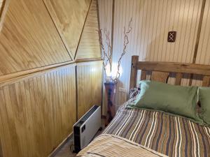 a bedroom with a bed in a room with wooden walls at Oceana Suites Coyhaique in Puerto Dunn