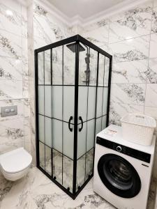 a bathroom with a washing machine and a toilet at Airport Deluxe Suites Otel in Trabzon +11 photos
