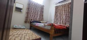 a room with a bed and a window with curtains at AGM Spacious Private AC 1BHK with Hall, Kitchen & Bath in Udupi