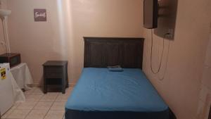 a bedroom with a bed with a blue blanket at Studio comodo con aire acondicionado in Caguas