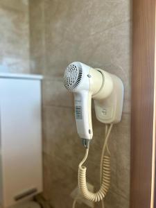 a blow dryer hanging on a wall in a bathroom at Irena Apartment near Aqua Park in Trebinje