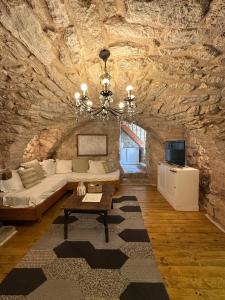 a living room with a couch in a stone wall at Authentic Stone House Tranquil Villa for Families and Groups in Grižane
