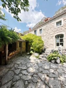 a stone house with a stone walkway in front of it at Authentic Stone House Tranquil Villa for Families and Groups in Grižane