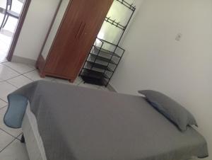 ein Schlafzimmer mit einem Bett und einem Bücherregal in der Unterkunft Executivo central 101 in Ipatinga