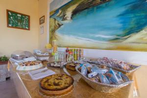 a table with food and a painting on the wall at Bed & Breakfast Isola Bella Lampedusa in Lampedusa