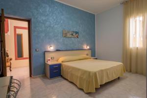 ランペドゥーザにあるBed & Breakfast Isola Bella Lampedusaの青い壁のベッドルーム1室(ベッド1台付)