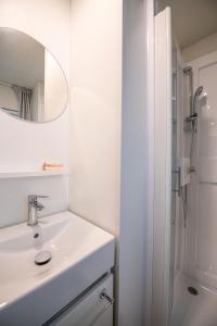 a white bathroom with a sink and a mirror at Camping Iscrixedda in Lotzorai