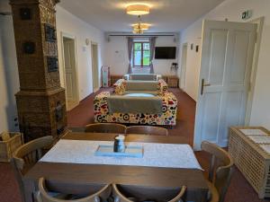 a room with two beds and a table and chairs at Penzion U Křížové Cesty in Tvrdkov