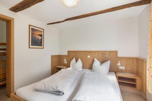 a bedroom with a large bed with white sheets and pillows at Ferienhof Pohl-Optimal für Familien in Lennestadt