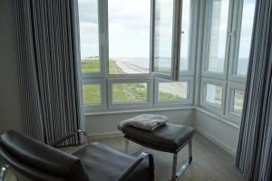 a room with chairs and windows with a view of the beach at Sturmvogel in Olpenitz +23 photos