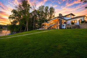 a house on a lawn with a sunset in the background at Willow Landing in Troutman