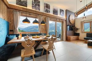 a dining room with a table and a large window at Chalet Bucher in Rifiano
