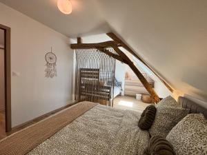 a bedroom with a bed and a staircase with a clock at Le Nid - Pause en Berry in Vignoux-sur-Barangeon