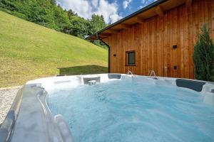 a hot tub in front of a wooden building at Chalet Bucher in Rifiano