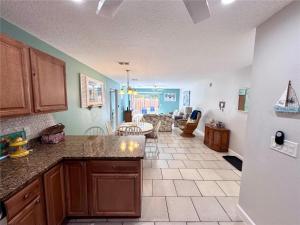 a kitchen with a counter top and a living room at 2BR/2BA condo Sienna Park in Sarasota