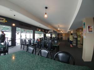 a dining room with tables and chairs in a restaurant at Pineacres Motel and Park in Kaiapoi