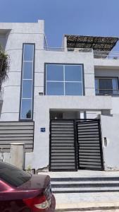a house with two garage doors and a car parked in front at Spacious 3BR Apartment in Prime Sheikh Zayed in Sheikh Zayed