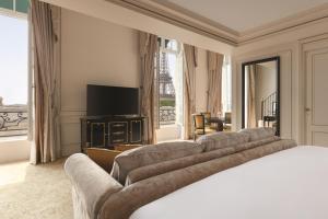 a hotel room with a bed and a flat screen tv at Shangri-La Paris in Paris