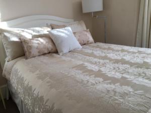 a white bed with pillows on top of it at CARIS Guest House in Southend-on-Sea