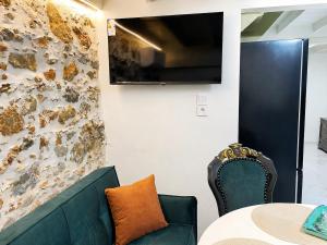 a room with a table and a couch and a tv at Chalikas Vintage Cottage in Mytilene