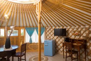 a blue refrigerator in a yurt with a table and a tv at Yurta Glamping B&B San Leone Agrigento - tra mare e pineta in Agrigento