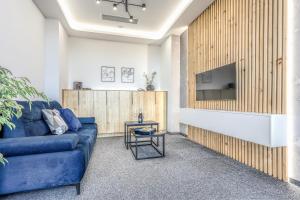 a living room with a blue couch and a tv at Apartmány Prusinovského in Kroměříž