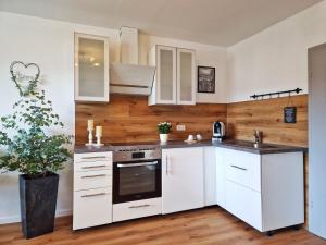 a kitchen with white cabinets and a stove top oven at FeWo Talblick - modern, charmant, Feldrand in Bad Orb