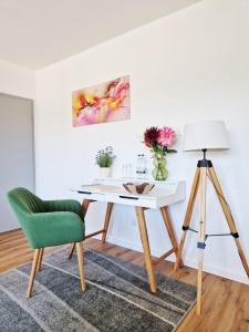a desk with a green chair and a lamp at FeWo Talblick - modern, charmant, Feldrand in Bad Orb +3 photos