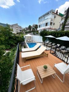 a balcony with white chairs and tables and a pool at Al Mare Vacation Home in Igalo +35 photos