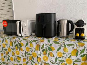 a counter top with a coffee maker and a microwave at Quarto privado na natureza in Fernao Ferro