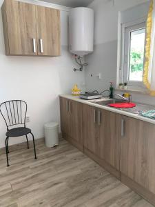 a kitchen with wooden cabinets and a chair in it at Quarto privado na natureza in Fernao Ferro