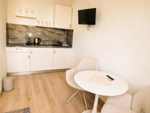 a small kitchen with a white table and chairs at Penzion Centrum in Sklené Teplice
