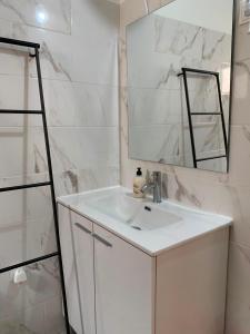 a bathroom with a white sink and a mirror at Quarto privado na natureza in Fernao Ferro