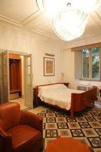 ein Schlafzimmer mit einem Bett, einem Stuhl und einem Kronleuchter in der Unterkunft Villa Laetitia in Rom + 14 Fotos