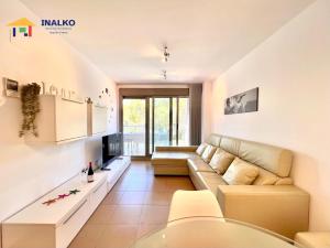 a living room with a couch and a tv at Alcocebre suites INALKO in Alcalà de Xivert