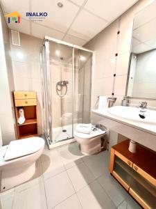 a bathroom with a toilet and a shower and a sink at Alcocebre suites INALKO in Alcalà de Xivert +15 photos