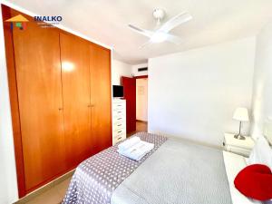 a bedroom with a bed and a wooden cabinet at Alcocebre suites INALKO in Alcalà de Xivert