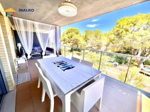 a dining room with a table and chairs on a balcony at Alcocebre suites INALKO in Alcalà de Xivert
