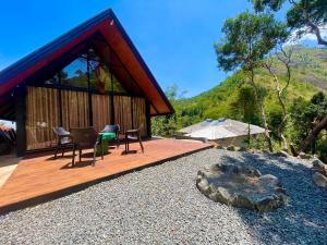 a house with a deck with chairs and a table at Citrine Belihuloya in Belihuloya +24 photos