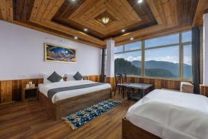 a bedroom with two beds and a window at Narkanda Heights by Splendid Retreat Hotels in Nārkanda
