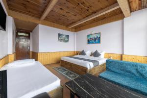 a bedroom with two beds and a couch at Narkanda Heights by Splendid Retreat Hotels in Nārkanda +13 photos