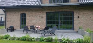 a patio with chairs and tables in front of a brick building at Villa by the Baltic Sea in Palanga