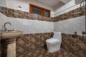a bathroom with a toilet and a sink at Narkanda Heights by Splendid Retreat Hotels in Nārkanda